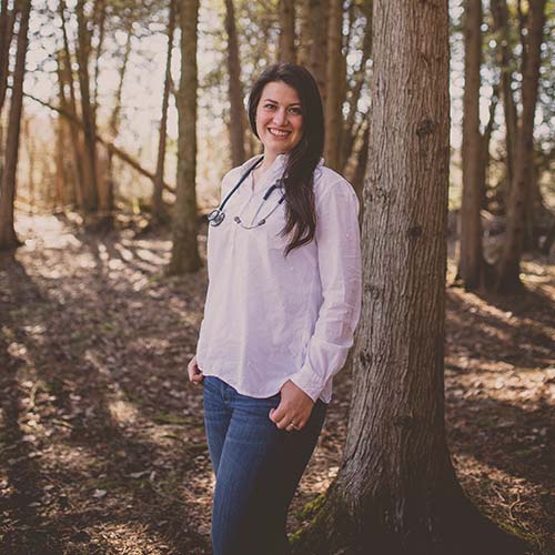 Jola Sikorski standing against a tree