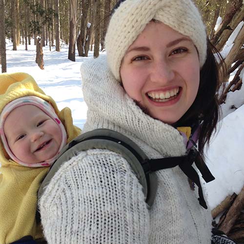 Jola Sikorski with a baby on her back, both smiling