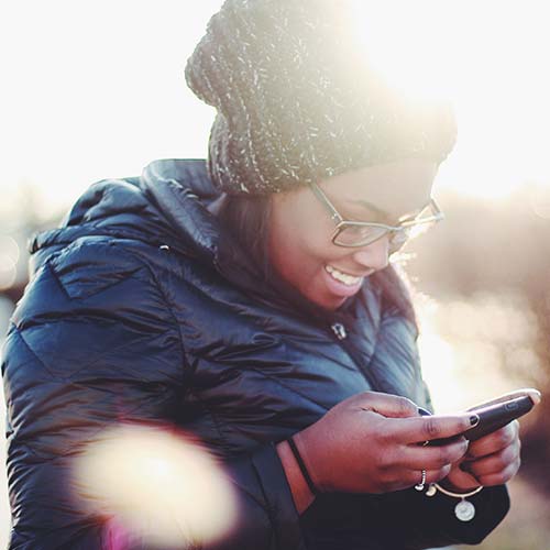 woman texting on her cellphone and smiling