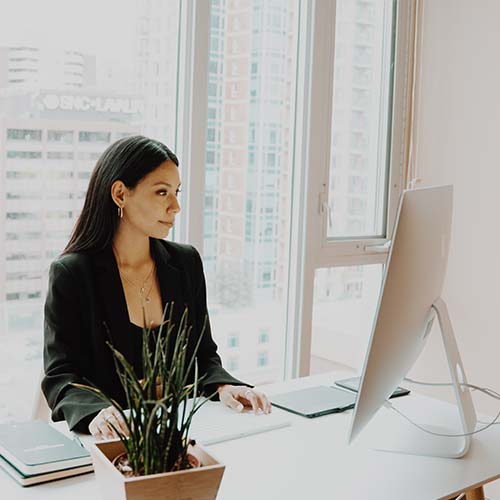 woman sitting at a desk working on a computer