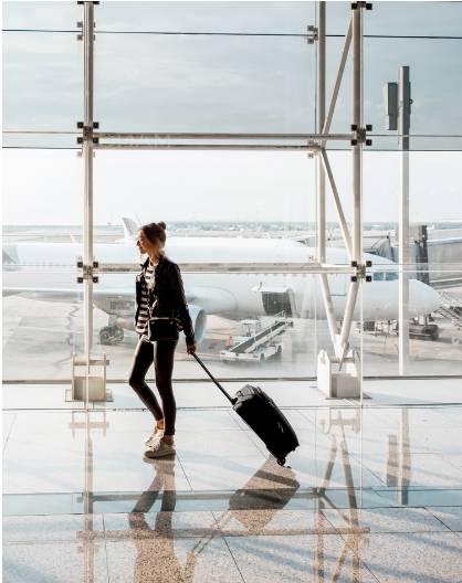 a woman pulling a suitcase through an airport